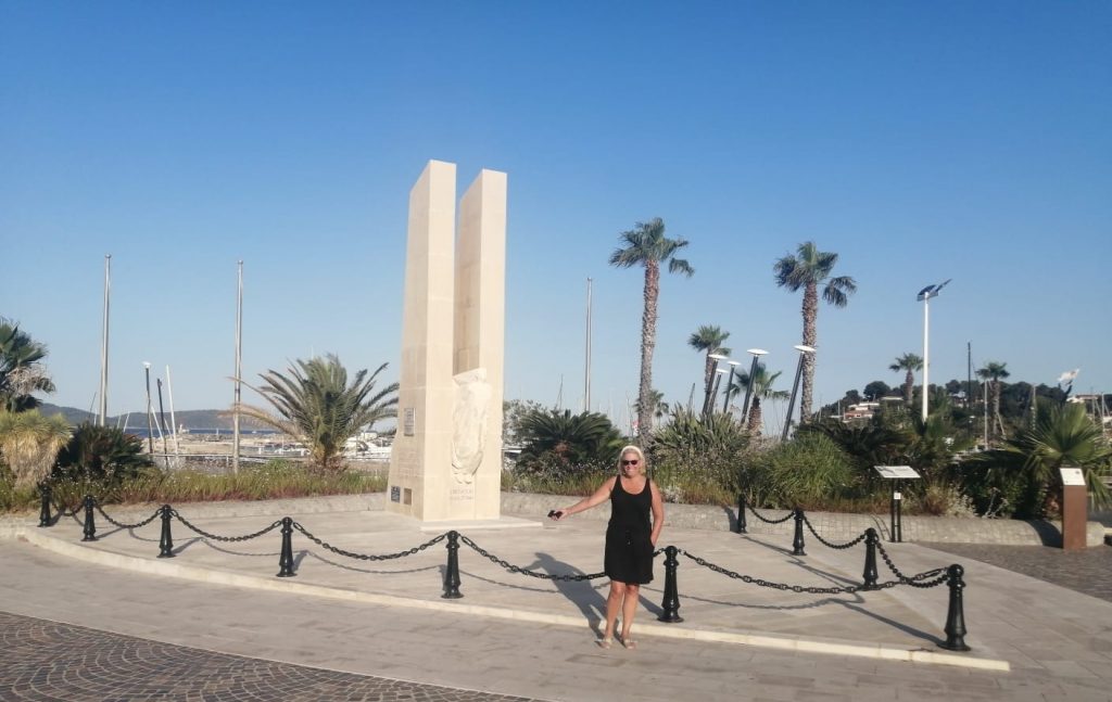 Sanja standing in front of the historic Allied monument under Azure Equilibrium
